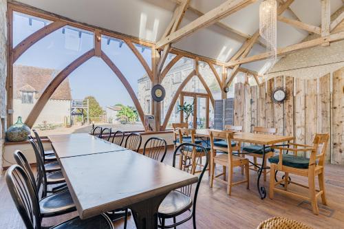 une salle à manger avec des tables et des chaises en bois dans l'établissement Gites Arches de Muschamp, à Cussay