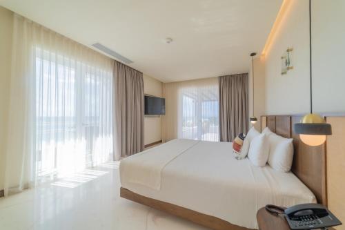 a hotel room with a bed and a large window at Hotel Indigo La Paz Puerta Cortes by IHG in La Paz