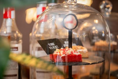 a dessert in a glass dome with a magnifying glass at Brownies & downieS Hotel Baarle in Baarle-Nassau