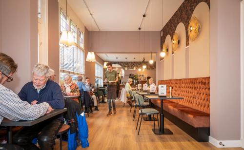 a group of people sitting at tables in a restaurant at Brownies & downieS Hotel Baarle in Baarle-Nassau