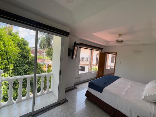 a bedroom with a bed and a balcony at Hotel Los Puentes Comfacundi in Girardot