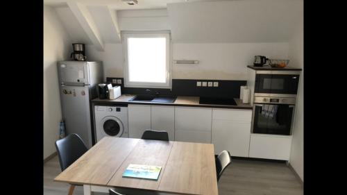 a kitchen with a wooden table and a table and chairs at Appartement 2 pièces à Saint René in Hillion