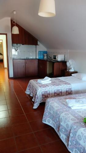 two beds sitting next to each other in a room at Quarto no Rua Grande 70 in Viana do Castelo