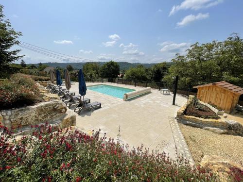une piscine avec chaises et parasols dans une cour dans l'établissement Les 3 metisses-eliza, au Bugue