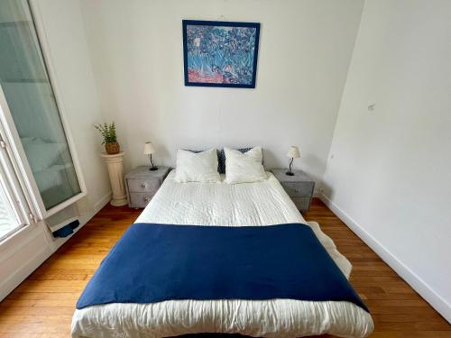 une chambre avec un grand lit avec une couverture bleue dans l'établissement Appartement Vaugirard - proche Tour Eiffel, à Paris