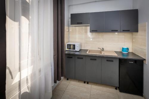 a kitchen with a sink and a microwave at 70s Guest room in Kraków