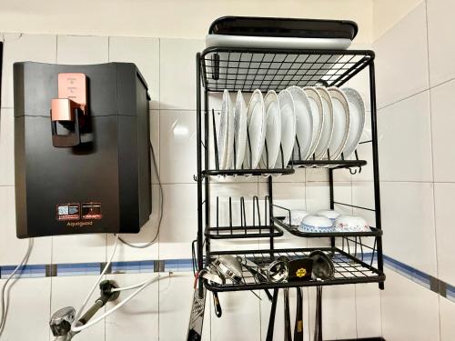 a shelf with plates on it in a kitchen at Lovely 3BHK Serviced Apt near ISKCON Temple, Juhu Mumbai in Mumbai