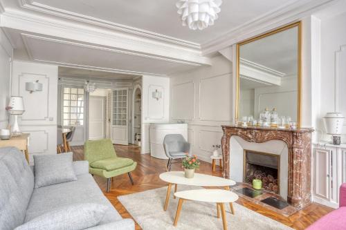 un salon avec un canapé et une cheminée dans l'établissement Le Colbert, à Versailles