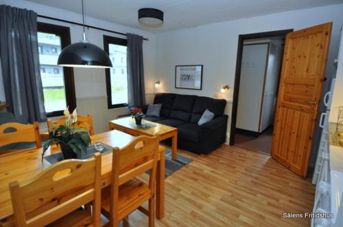 a living room with a couch and a table at SÄLEN, Ski in-Ski out, Lägenhet 12C Grå Byn in Sälen