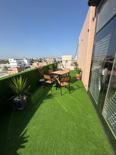 a patio with a table and chairs on a balcony at Résidence CHEZ TIMERA in Keur Massar