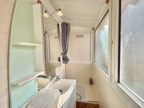 une salle de bain avec une baignoire, un lavabo et un miroir dans l'établissement Appartement centre-ville Ajaccio 1er Consul, à Ajaccio