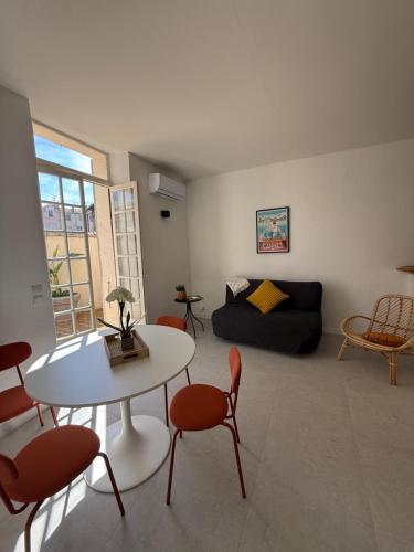 un salon avec une table, des chaises et un canapé dans l'établissement Superbe 2P, clim, terrasse au calme, tout à pied, à Cannes