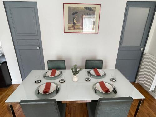 une salle à manger avec une table et des chaises blanches dans l'établissement Appartement Vaugirard - proche Tour Eiffel, à Paris