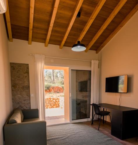 a living room with a couch and a table and a window at Quinta-lina de serpins in Serpins