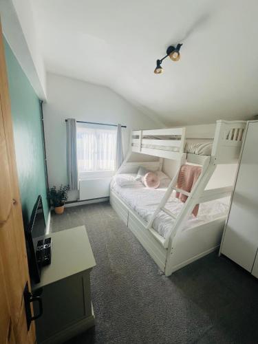 a bedroom with two bunk beds and a desk at The Annexe at Tenniside in Perranporth