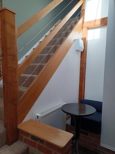 a stairway with a table and a stair case at The Studio Loft - A cosy town centre apartment in Tewkesbury