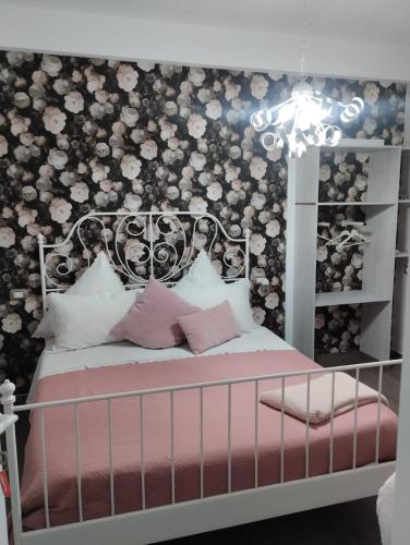 a bedroom with a bed with a floral wall at Al Passo di Thalia in Ricadi