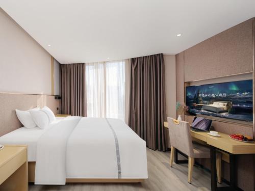 a hotel room with a large bed and a desk at Yishang Hotel - Guangzhou Railway Station Yuexiu Park Subway Station in Guangzhou