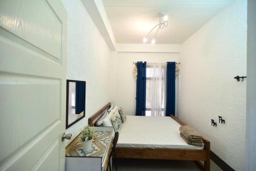 a small bedroom with a bed and a window at REEF HOUSE BACNOTAN White sand beach front with Private Swimming pool in Bacnotan