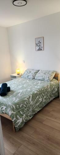 - un lit avec une couette verte et blanche dans une chambre dans l'établissement Le maillot VII, à Castres