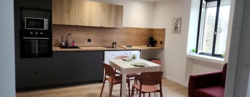 une cuisine avec une table blanche et des chaises dans l'établissement Le maillot VII, à Castres