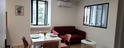 un salon avec une chaise rouge et une table dans l'établissement Le maillot VII, à Castres