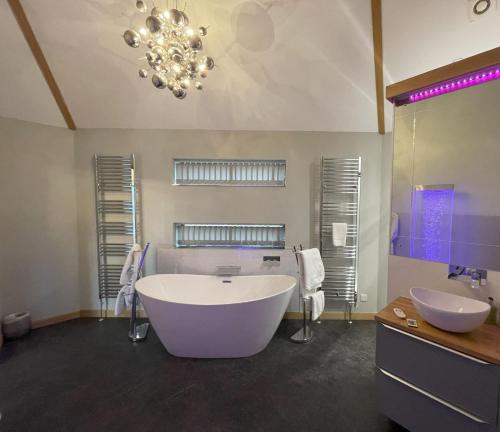 a large bathroom with a large tub and two sinks at Silver Birch Treehouse in Glenshee