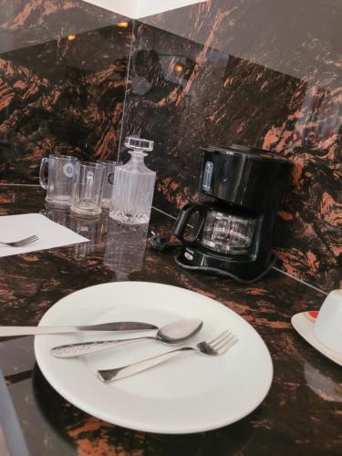 a white plate with silverware on a table at Pearl House Homestay in Dickwella