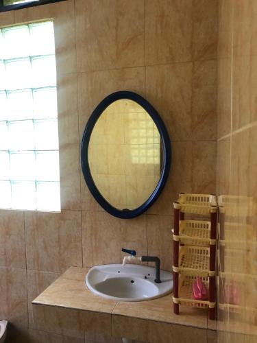 ein Badezimmer mit Waschbecken und Spiegel in der Unterkunft Coaster Cottages in Ohoililir