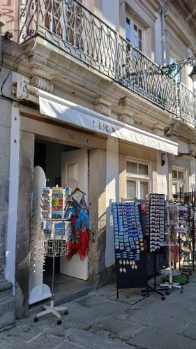 a store with a balcony on the side of a building at Quarto no Rua Grande 70 in Viana do Castelo