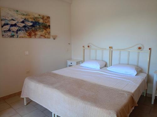 a bedroom with a white bed with two pillows at Rena Studios in Paleokastritsa