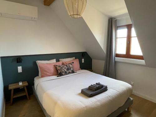 a bedroom with a large bed with pink pillows at L'Adresse - Rempart Sud - Eguisheim avec garage privé in Eguisheim