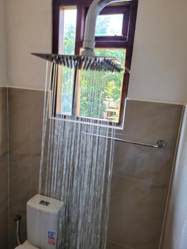 a shower curtain in a bathroom with a window at Pearl House Homestay in Dickwella