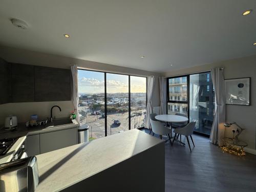 a kitchen and dining room with a view of a city at Penthouse - Harbour Views in Poole