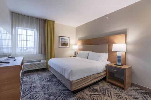 a hotel room with a bed and a desk at Candlewood Suites San Marcos by IHG in San Marcos