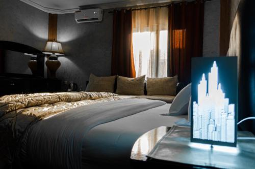 a bedroom with a bed with a table with a display at Hotel de Fez in Pointe-Noire