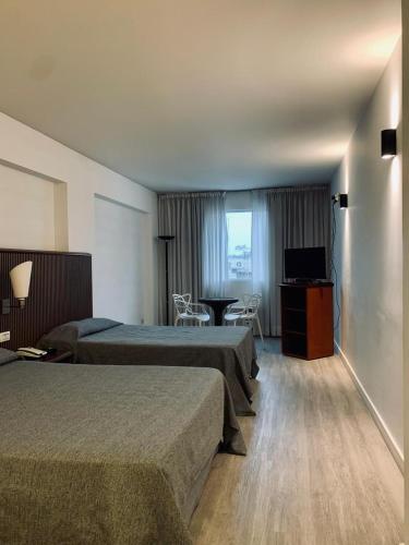 a hotel room with two beds and a television at Cristal Palace Hotel in Buenos Aires