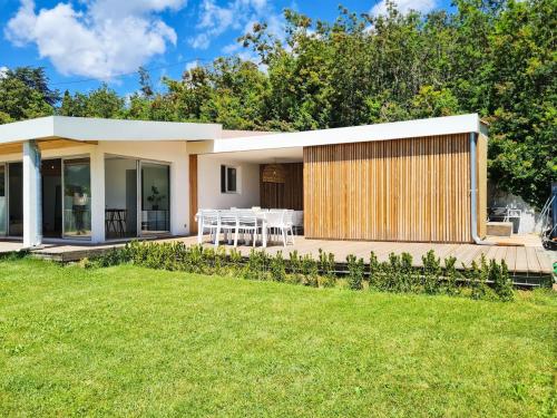 a house with a wooden deck and a grass yard at Villa Californienne au calme in Berre-les Alpes