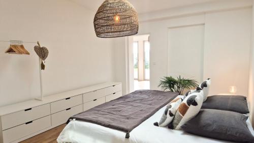 a white bedroom with a bed and a dresser at Villa Californienne au calme in Berre-les Alpes