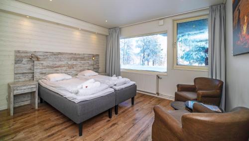 a bedroom with a bed and a couch and a chair at Aurora Mountain Lodge in Lannavaara