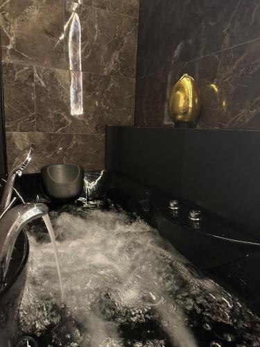 La salle de bains est pourvue d'une baignoire avec de l'eau. dans l'établissement LA CHAMBRE DES SECRETS, Magique, Hyper-centre, 9 Couchages, à Mâcon