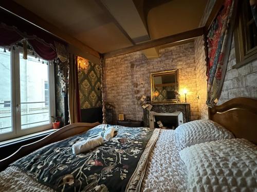 une chambre avec un lit et un mur de briques dans l'établissement LA CHAMBRE DES SECRETS, Magique, Hyper-centre, 9 Couchages, à Mâcon