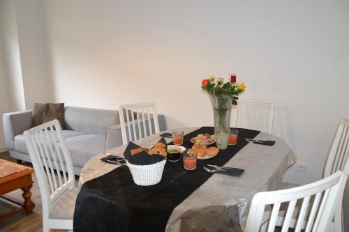 a dining room table with food and a vase of flowers at La commanderie secteur calme et familial in Échirolles