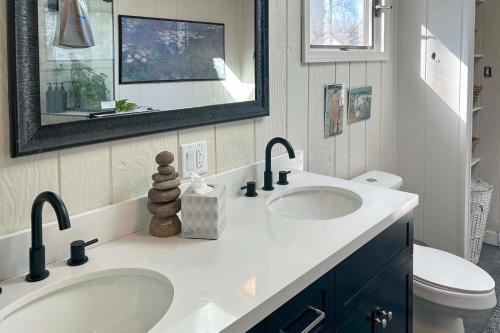 a bathroom with two sinks and a mirror at Sawyer Retreat with Fire Pit Less Than 2 Mi to Beaches! in Sawyer