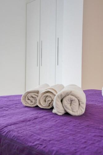 a pile of towels sitting on top of a bed at Hotel Malibù in Rimini