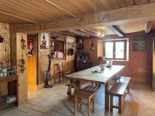 une salle à manger avec une table et des chaises en bois dans l'établissement Chalet 1830 au pied du MONT CHARVIN, à La Savatte