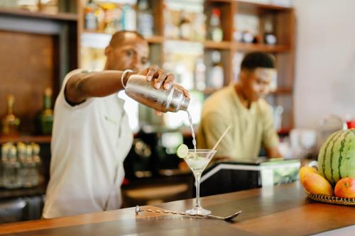 a man is making a drink in a bartender at Loharano Lodge in Ambaro