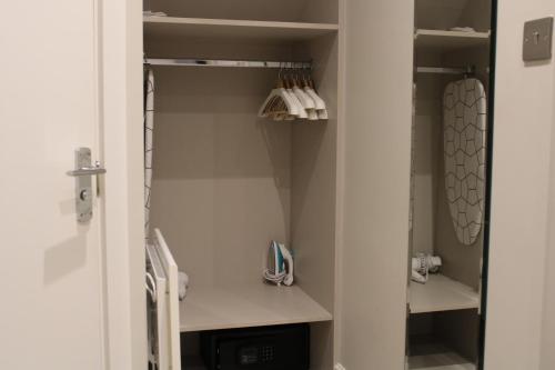 a walk in closet with white shelves in a bathroom at NOX Kensington in London