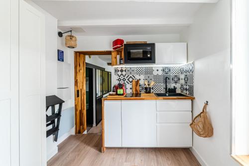 une cuisine avec des armoires blanches et un comptoir dans l'établissement SV - Cosy Au Cœur du Panier, à Marseille