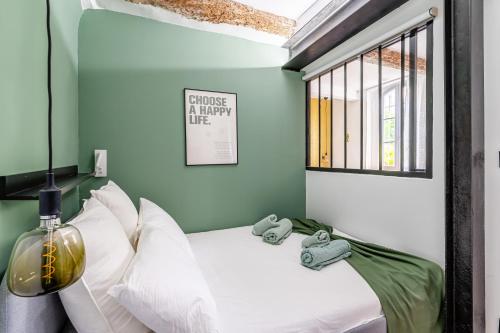 une chambre avec un lit avec des oreillers blancs et une fenêtre dans l'établissement SV - Cosy Au Cœur du Panier, à Marseille